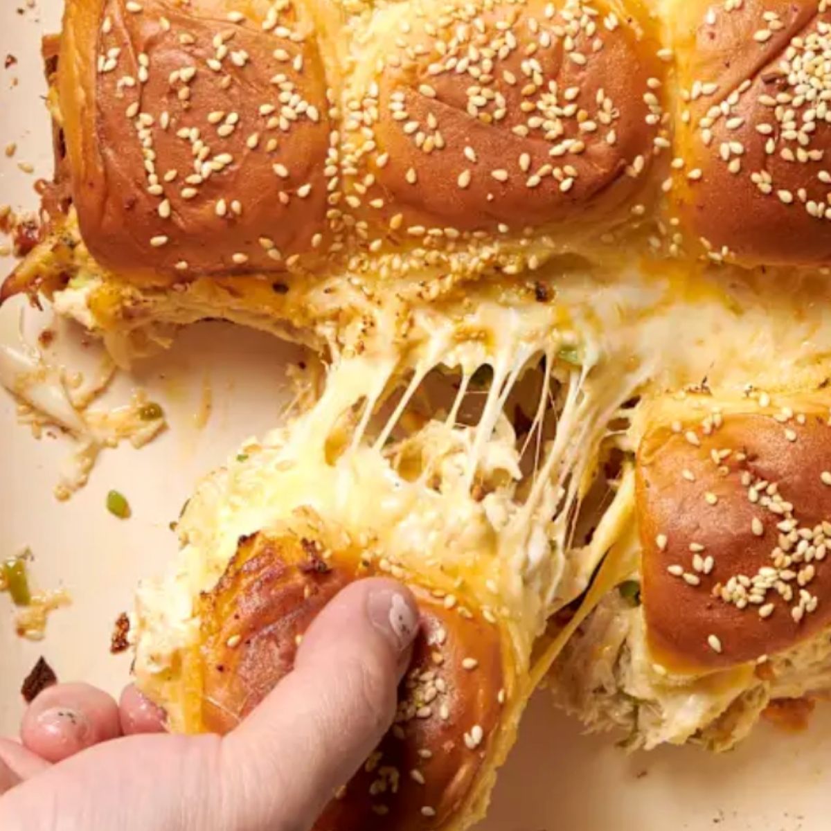 Reuben sliders being pulled apart with perfect cheese pull..