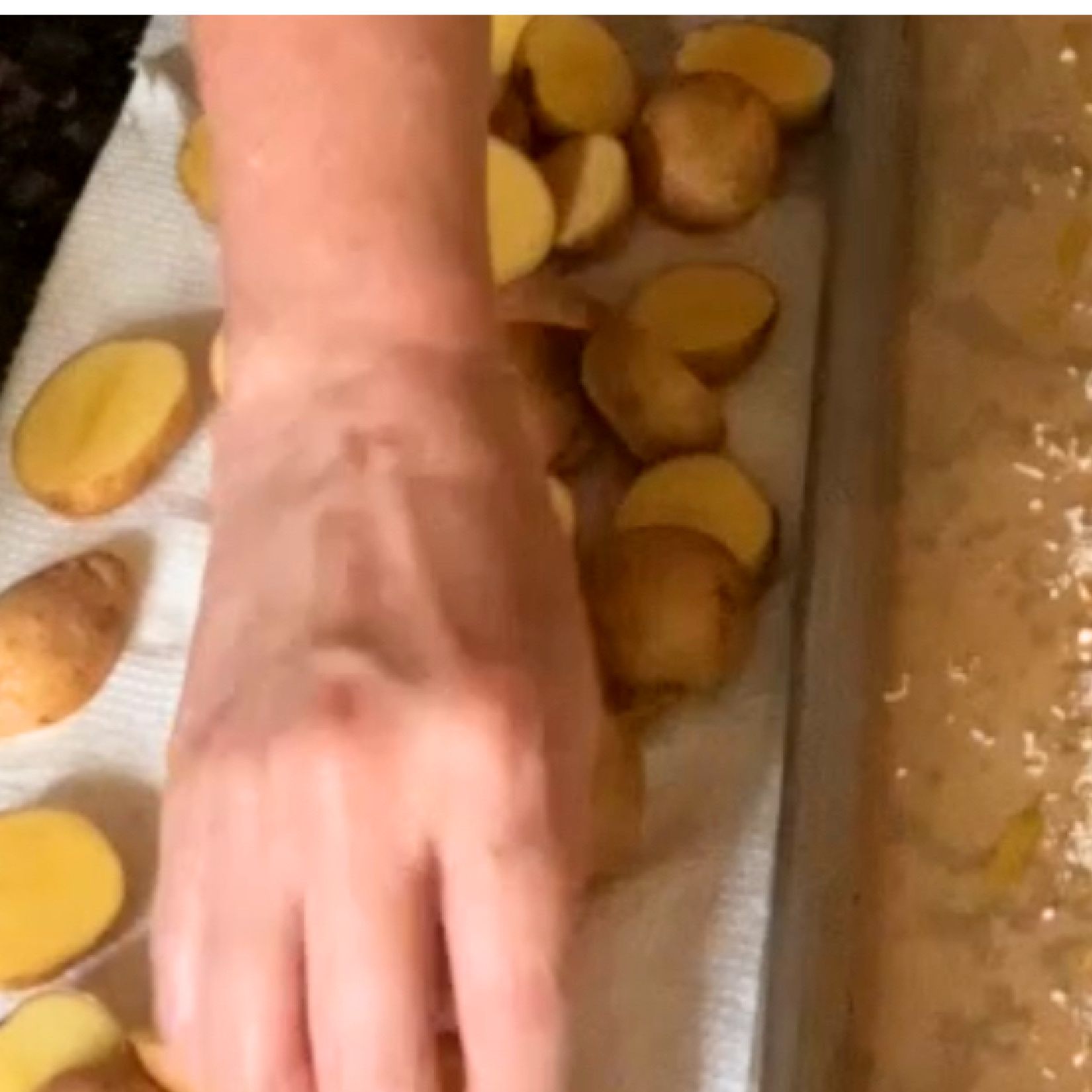 Baby potatoes cut in half on a paper towel.