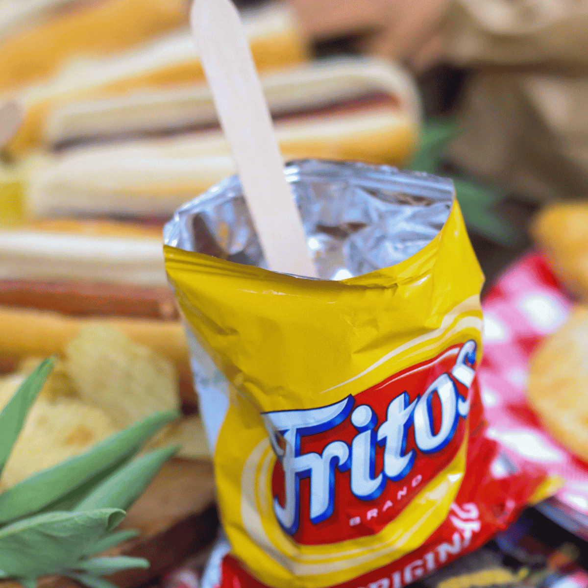 Individual Frito bag with chili and a spoon.