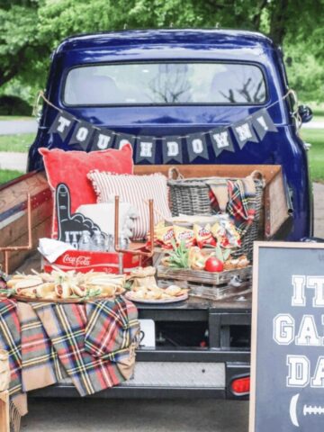Tailgate food ideas with a game day truck setup, hot dog board, Frito bags, snack mix, and football party decorations.