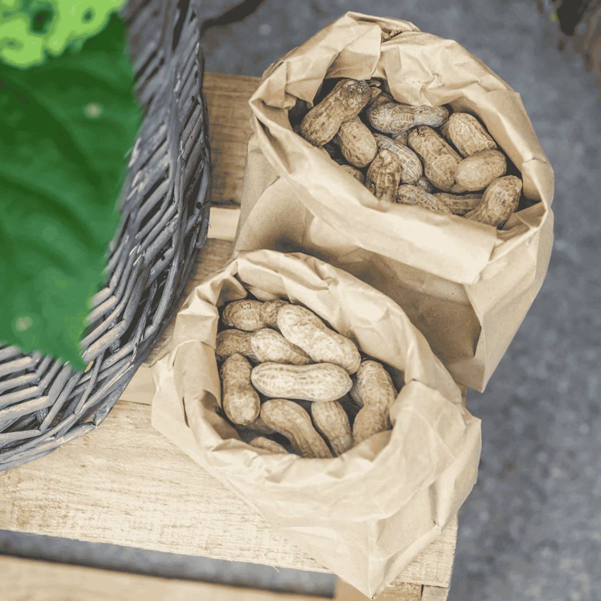 peanuts in lunchbags on wood table.