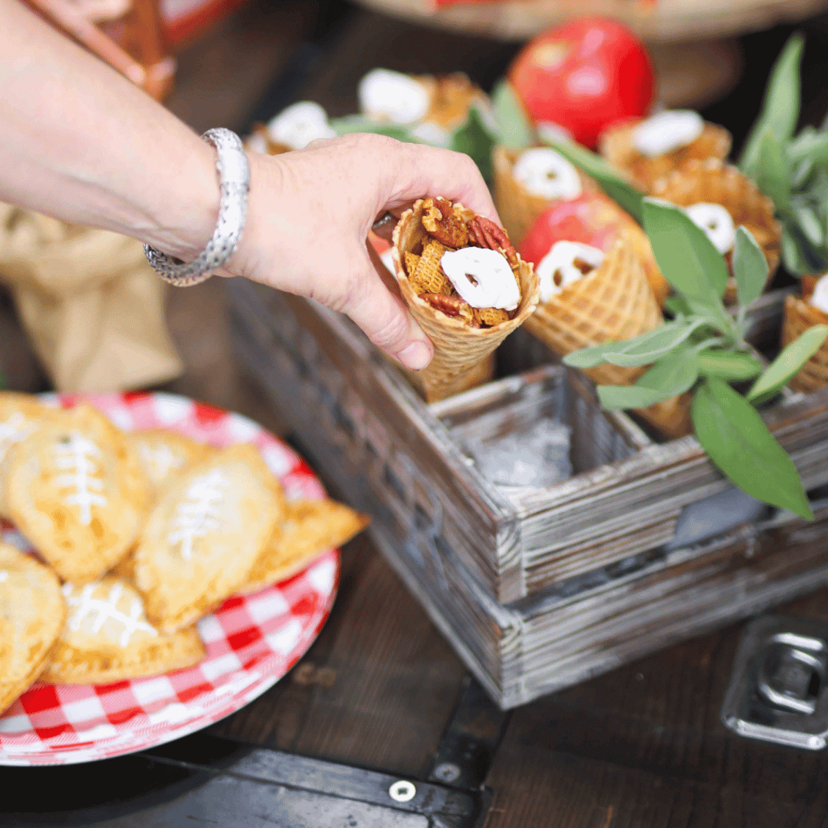 Praline Pecan Crunch Snack Mix in a waffle cone with hand taking one.