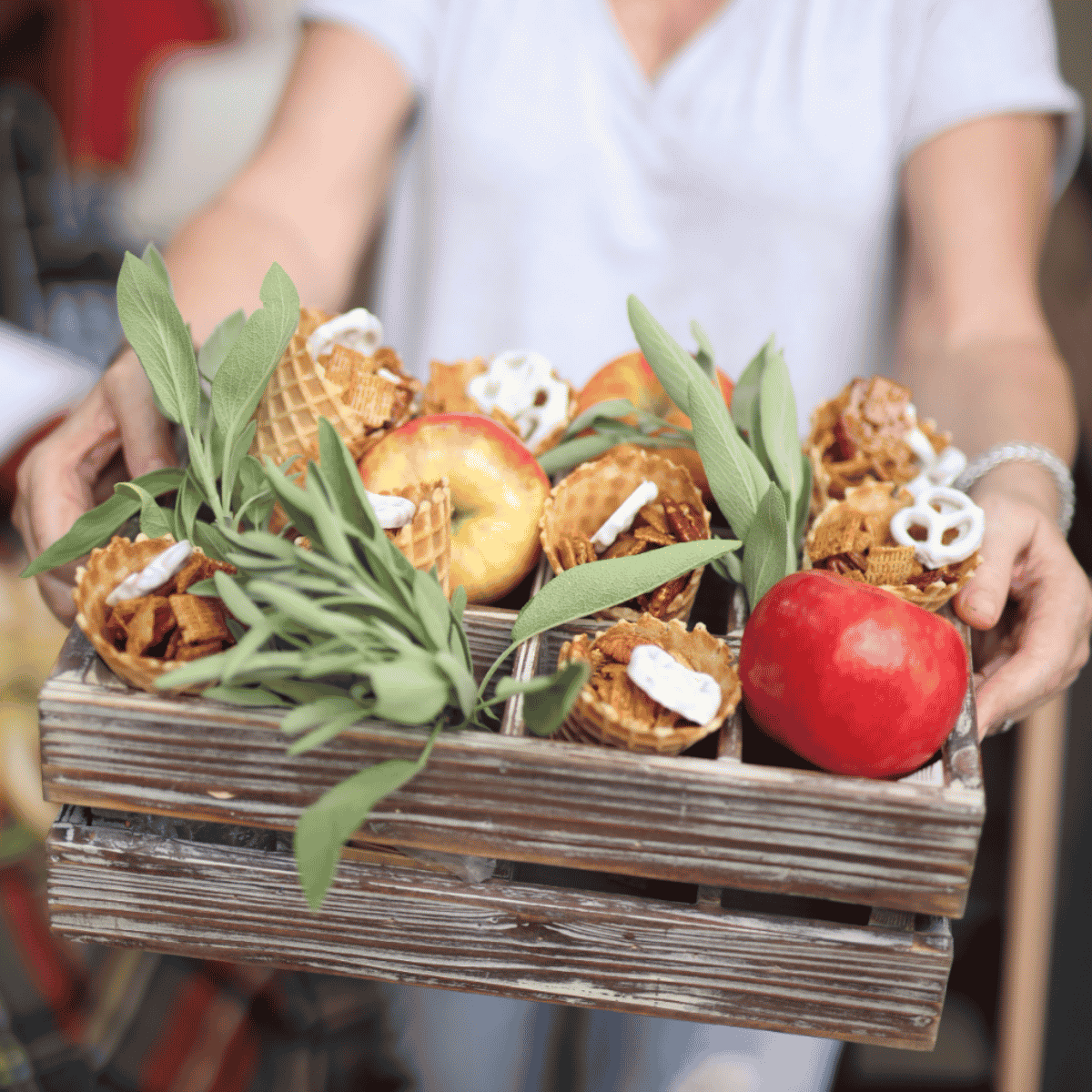 Sweet and salty snack mix served in waffle cones in a wooden drink crate for easy tailgate food.