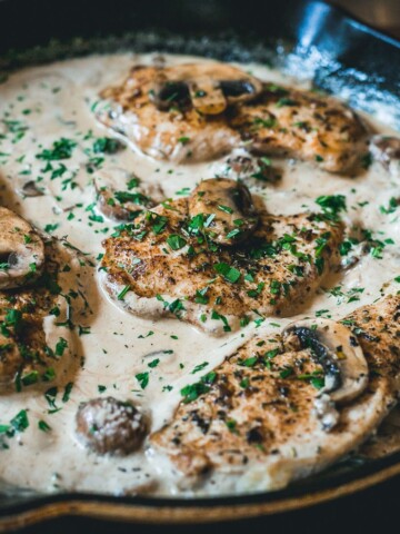 creamy parmesan chicken in cast iron skillet