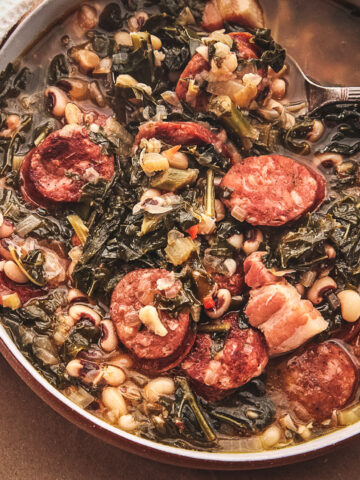 Black Eyed Peas soup, sausage and kale in a pan with a cloth with a spoon