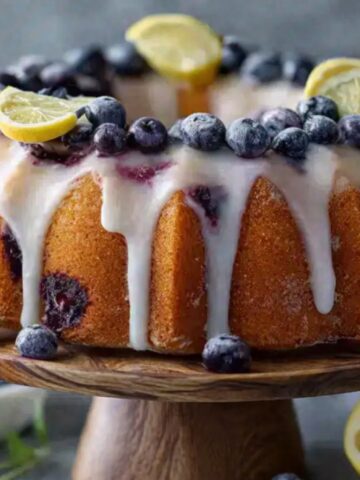 Lemon blueberry bundt cake with glaze, lemon slices and blueberries.