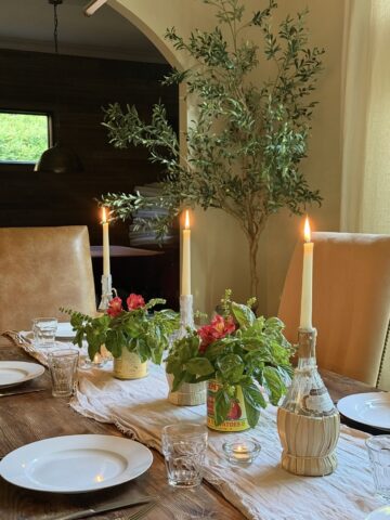 Italian dinner table setting with basil and candles