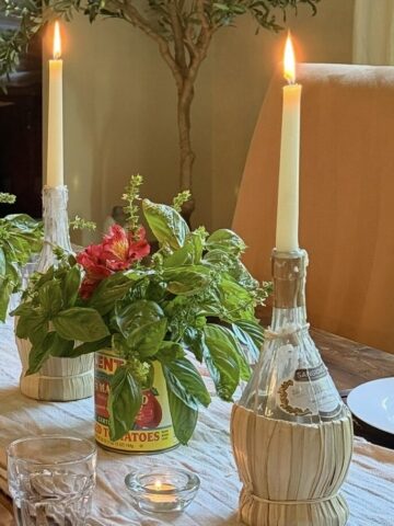 Italian dinner table setting with basil and candles