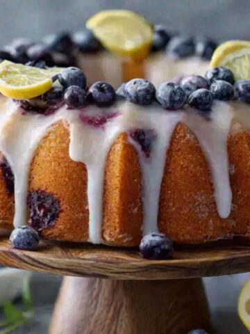 Lemon blueberry bundt cake with glaze, lemon slices and blueberries.