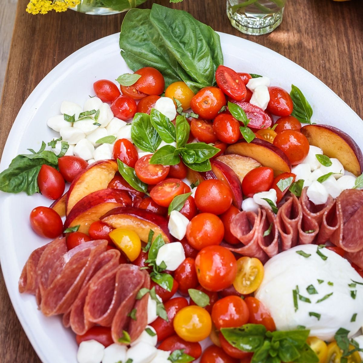 platter with tomaotes, cured meats, peaches, buratta and basil