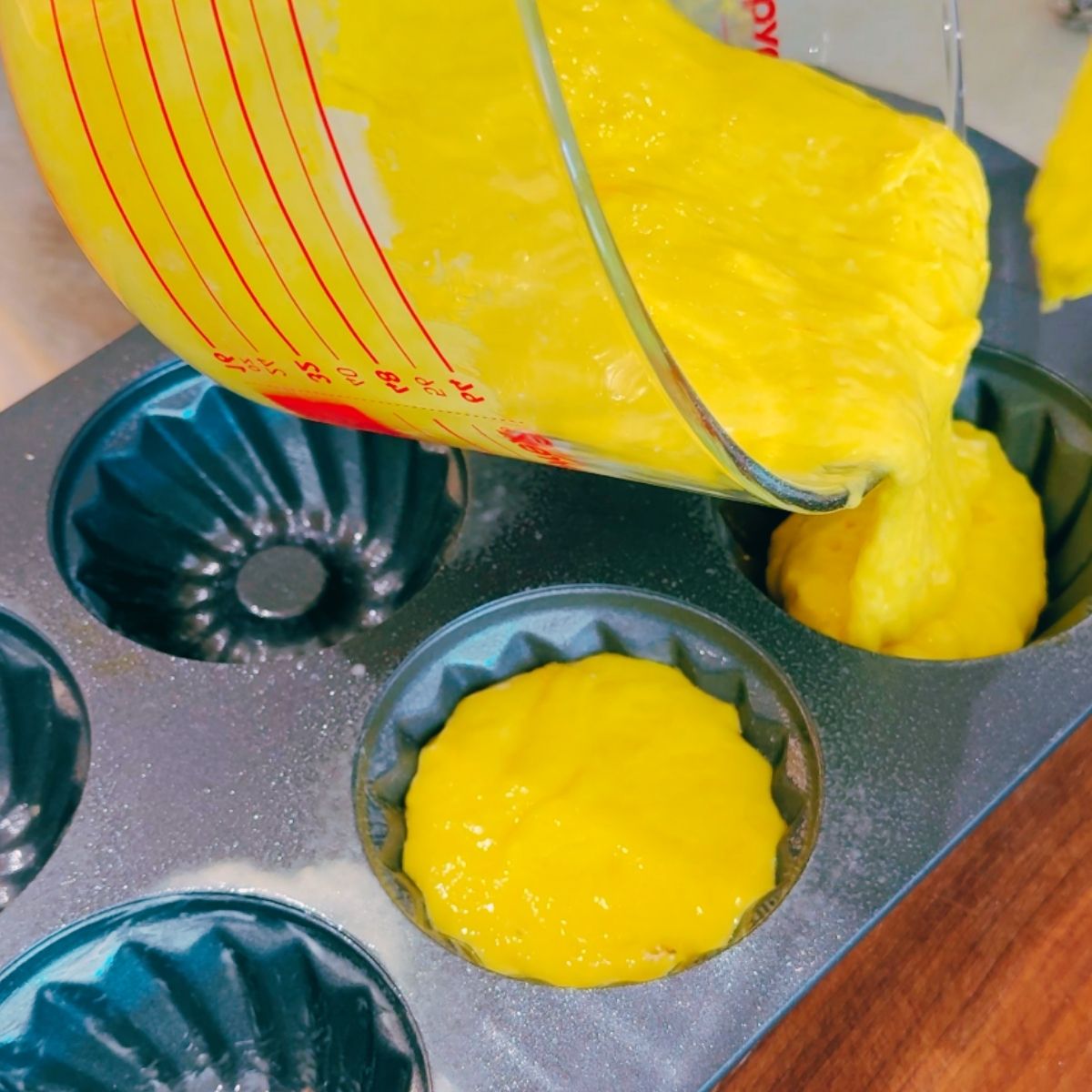 Lemon blueberry Bundt cake batter be poured into individual bundt pans.