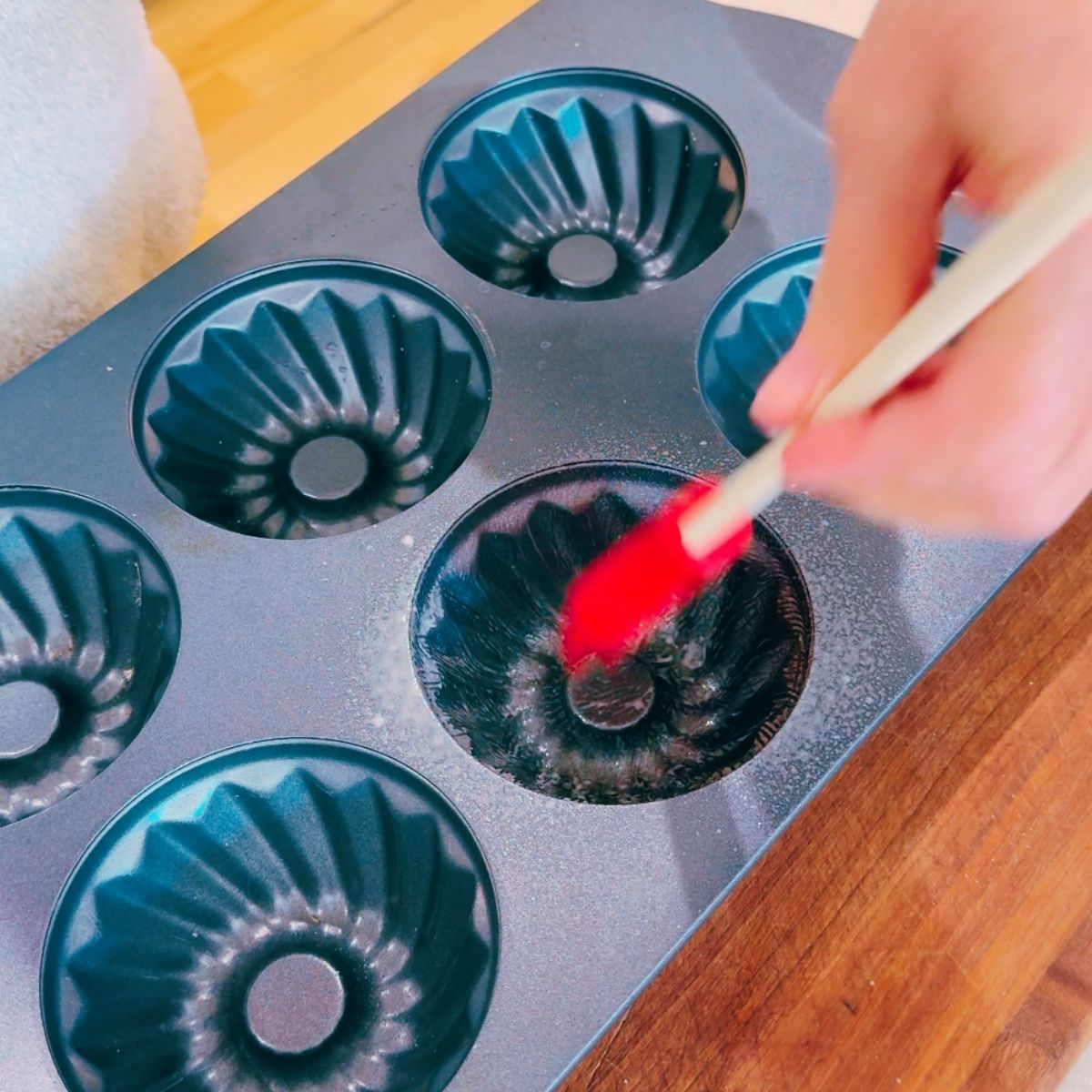 Preparing a Bundt pan to ensure the cake doesn't stick.