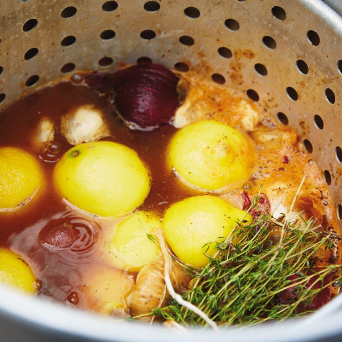 Shrimp boil pot filled with water with lemons, onions all base seasoning, beer in thyme.
